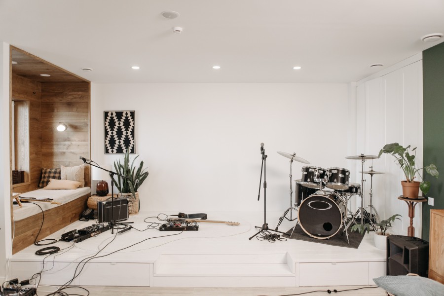 Black and white photo of a professional music recording studio with monitors, mixing console, and acoustic paneling.